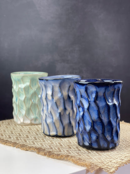 Three ceramic cups of different colors